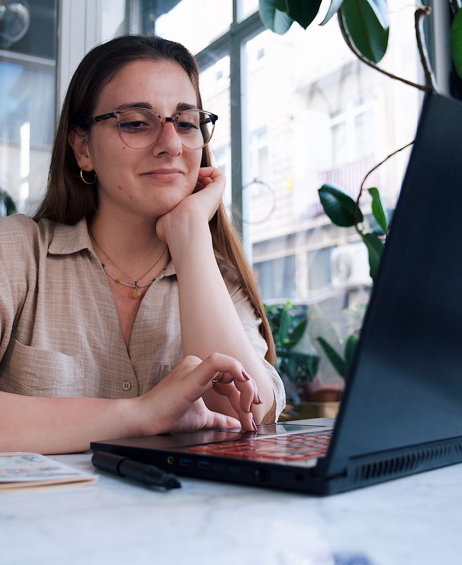 A student smiling at her laptop
