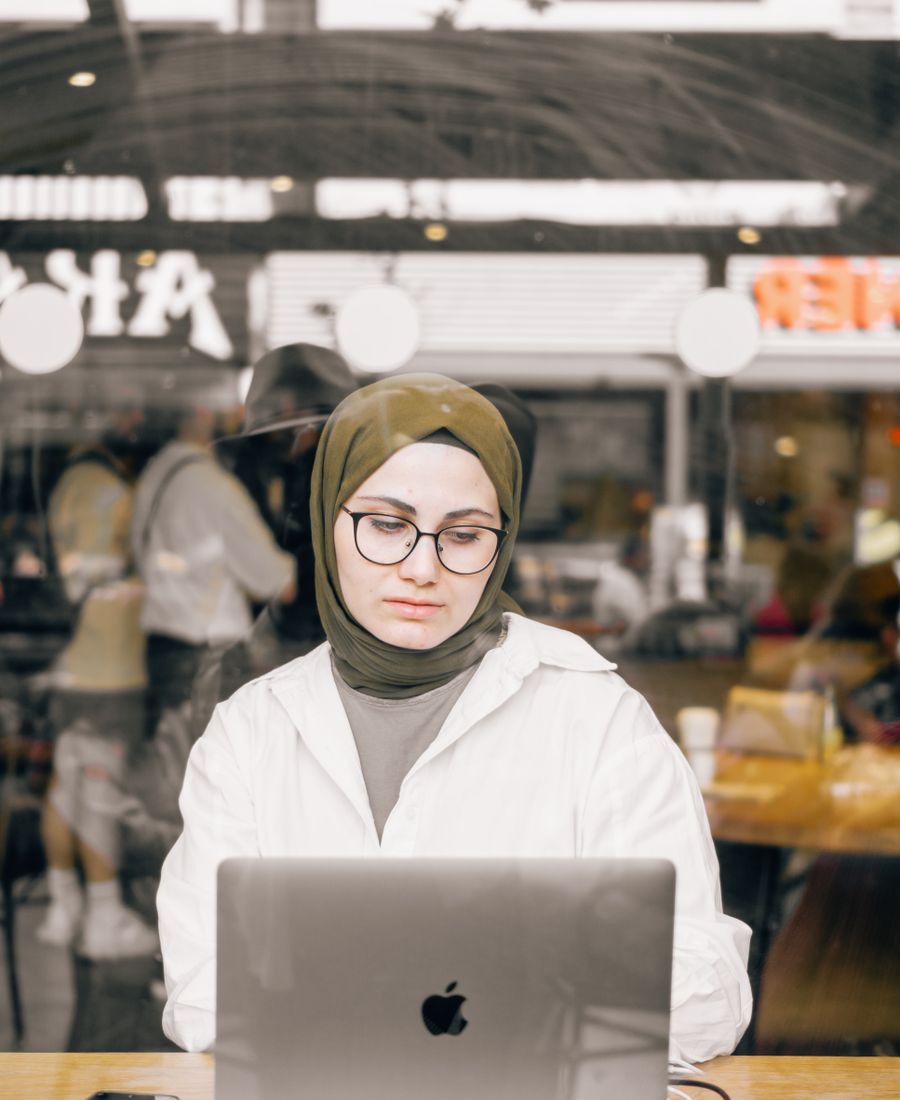 A student joining a lesson on a laptop in a café