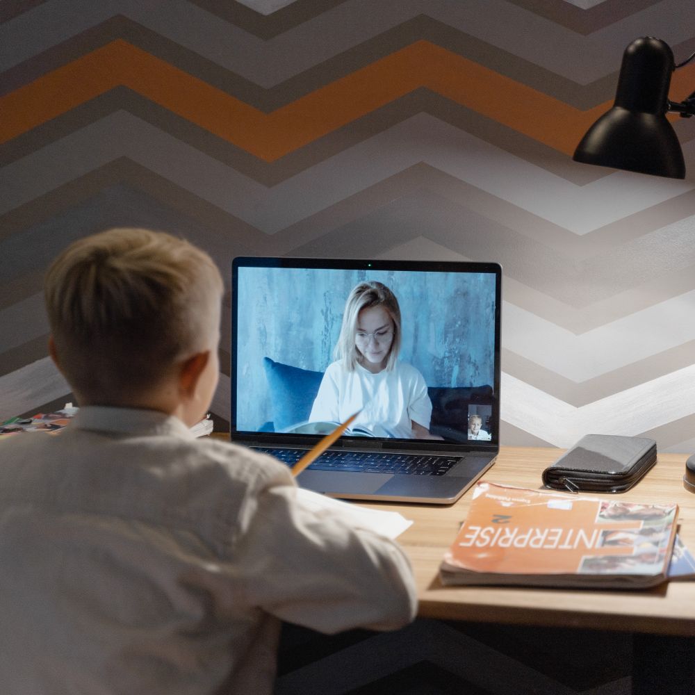 A boy talking with his teacher in an online lesson